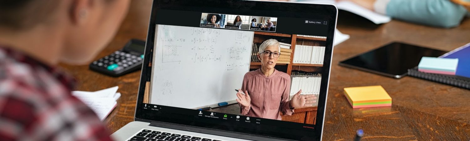 Teacher explaining lesson in video call while girl taking notes. Rear view of university student understanding concepts online while making notes. Young woman studying on computer and writing on notebook sitting in college library.